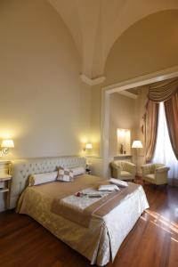 a bedroom with a large bed and a large window at SANTA CHIARA SUITE HOTEL & SPA - Lecce in Lecce