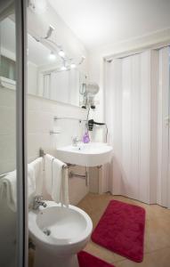 a white bathroom with a sink and a toilet at Casa del Clown in Trapani