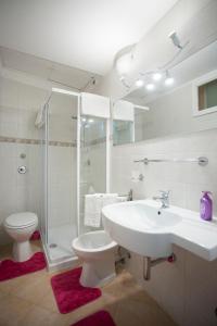 a bathroom with a sink and a toilet and a shower at Casa del Clown in Trapani