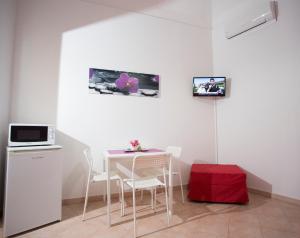 a dining room with a table and chairs and a microwave at Casa del Clown in Trapani