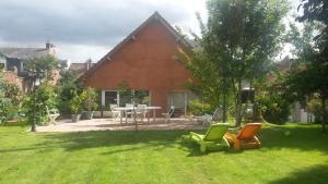 a yard with chairs and a table in front of a house at Le Relais De L'Aube in Villers-Bretonneux