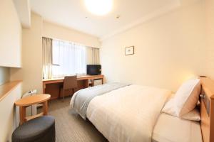 札幌市にあるリッチモンドホテル 札幌駅前のベッドとデスクが備わるホテルルームです。