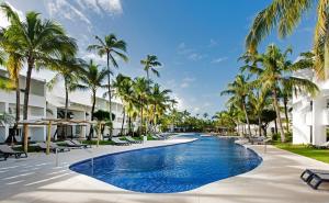 a pool at the resort with palm trees at Occidental Punta Cana - All Inclusive in Punta Cana +98 photos