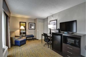 a hotel room with a flat screen tv and a living room at Best Western Plus Hanes Mall in Winston-Salem