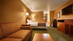 ein Hotelzimmer mit einem Bett und einem Sofa in der Unterkunft Best Western Parker Inn in Parker