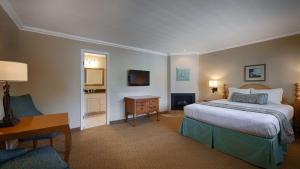 a bedroom with a bed and a desk and a television at Carmel Bay View Inn in Carmel +15 photos