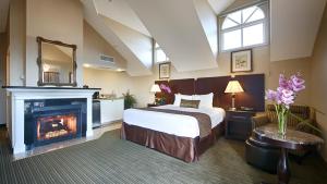 a bedroom with a bed and a fireplace at Best Western Plus Dana Point Inn-by-the-Sea in Dana Point