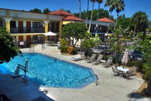 une grande piscine en face d'un hôtel dans l'établissement Best Western Orlando East Inn & Suites, à Orlando
