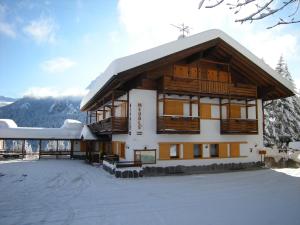 a large building with snow on the ground at Hotel Piccolo Pocol in Cortina dʼAmpezzo