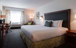 a hotel room with a large bed and a desk at Best Western Plus University Park Inn & Suites in Ames
