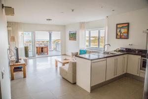 a kitchen and living room with a view of the ocean at Seaview 2 Bedroom - apt40 - Blue Bay Curacao in Willemstad