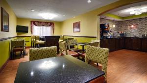 ein Restaurant mit einem Tisch und Stühlen sowie einer Bar in der Unterkunft Best Western Canton Inn in Canton