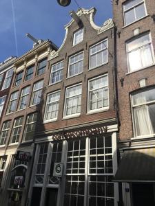 a tall brick building with windows on a street at Nine Streets Inn in Amsterdam