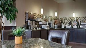 a restaurant with a table and chairs and a counter at Best Western Plus Cushing Inn & Suites in Cushing