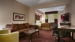 a hotel room with a couch and a bed at Best Western Plus Cushing Inn & Suites in Cushing