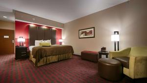 een hotelkamer met een bed en een stoel bij Best Western Plus Cushing Inn & Suites in Cushing