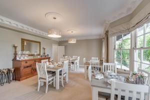 a dining room with white chairs and tables and a mirror at Bellevue Boutique Lodge in Taupo +57 photos