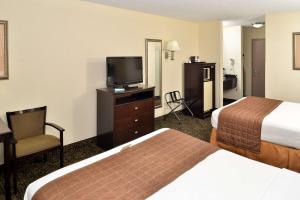 a hotel room with two beds and a flat screen tv at Best Western Elyria in Elyria