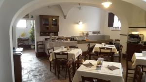 a restaurant with white tables and chairs in a room at Fattoria il Casone in Monteriggioni