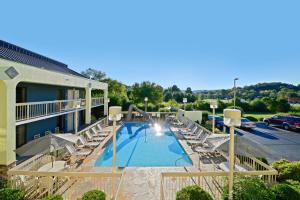 a hotel with a swimming pool and lounge chairs at Best Western Cades Cove Inn in Townsend