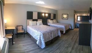 a hotel room with two beds and a desk at Best Western Cades Cove Inn in Townsend