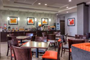 a restaurant with tables and chairs and a counter at Best Western Plus Coweta's 1st Hotel in Coweta