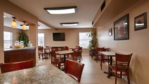 a restaurant with tables and chairs and a bar at Best Western Padre Island in Corpus Christi