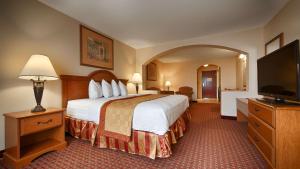 a hotel room with a bed and a flat screen tv at Best Western Casa Villa Suites in Harlingen