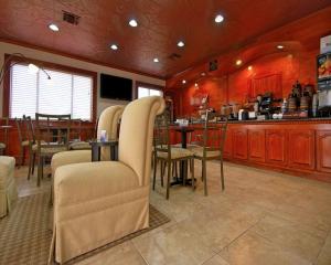 a restaurant with a bar with chairs and a table at Americas Best Value Inn Kingsville in Kingsville