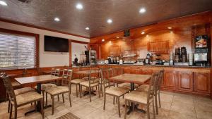 Americas Best Value Inn Kingsville في كينغزفيل: وجود بار بطاولات وكراسي خشبية في المطعم