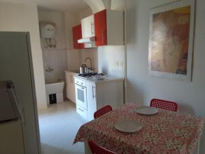 a kitchen with a table and chairs and a kitchen with a table and a table at The House on the Beach in Giardini Naxos