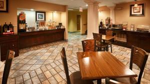 um restaurante com mesas de madeira e um bar em Best Western San Marcos em San Marcos