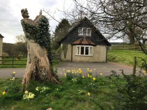 een standbeeld van een persoon die naast een huis staat bij Godshill Park Cottages in Godshill