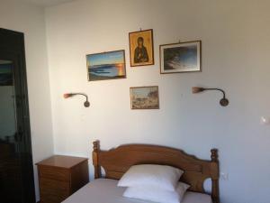 ein Schlafzimmer mit einem Bett und drei Bildern an der Wand in der Unterkunft Delfinario in Pteleos