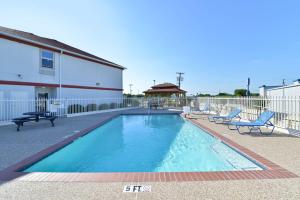 a swimming pool with two chairs and a gazebo at Best Western Limestone Inn and Suites in Mexia