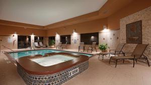 uma grande piscina num quarto com cadeiras e mesas em Best Western Plus Lytle Inn and Suites em Lytle