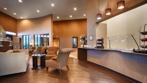 a lobby of a hotel with a bar and chairs at Best Western Plus Lackland Hotel and Suites. in San Antonio
