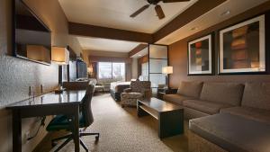a living room with a couch and a table at Best Western Plus Lackland Hotel and Suites. in San Antonio