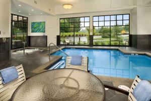 a swimming pool with a table and chairs and a table and a dining room at Best Western Plus Puyallup Hotel in Puyallup