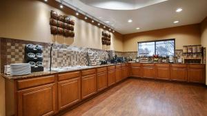 a large kitchen with wooden cabinets and a counter at Best Western Plus Palo Alto Inn and Suites in San Antonio