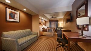a hotel room with a couch and a desk and a bedroom at Best Western Plus Palo Alto Inn and Suites in San Antonio
