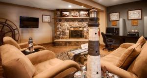 a living room with couches and a stone fireplace at Best Western Maritime Inn in Sturgeon Bay