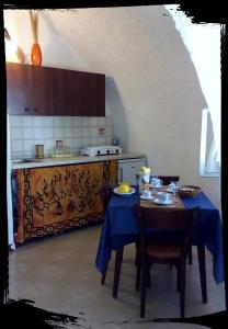 een keuken met een tafel met een blauwe tafeldoek bij Oltremare in Triscina