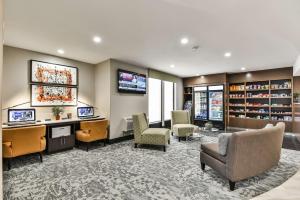 a library with chairs and a desk and a tv at Best Western Plus Cambridge Hotel in Cambridge