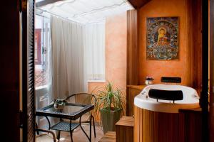 uma casa de banho com um lavatório, uma mesa e uma cadeira em Pousada Villa Capivary Campos do Jordão em Campos do Jordão