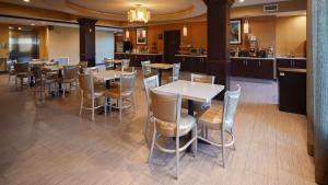a restaurant with tables and chairs and a bar at Best Western Plus New Orleans Airport Hotel in Kenner