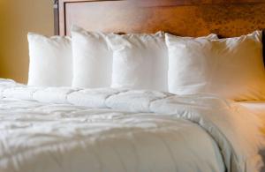 un letto con cuscini bianchi e testiera del letto di The Wildwood Hotel a Wildwood
