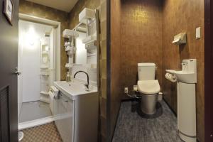 a bathroom with a toilet a sink and a mirror at Khaosan World Tennoji in Osaka