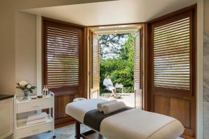 a bedroom with a bed and a woman sitting on a patio at Spicers Clovelly Estate in Montville