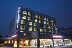 a tall building with many windows at night at Royal Square Hotel Seoul in Seoul